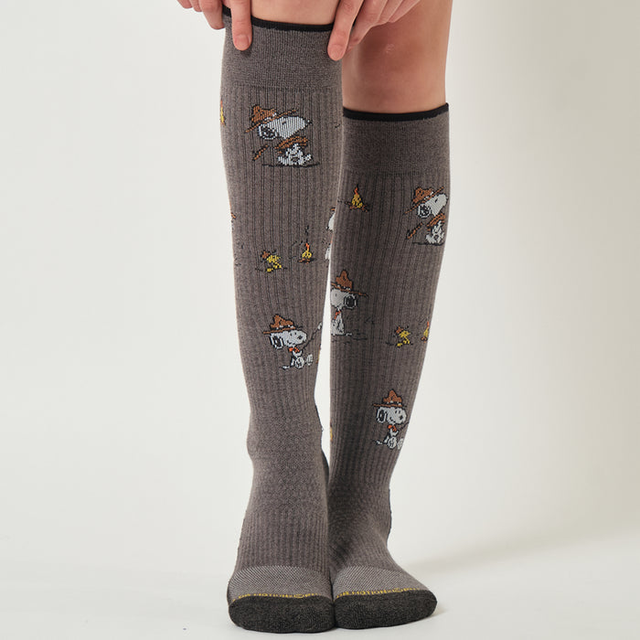 Light grey marl knee-high compression socks with a Snoopy campfire design, worn in an outdoor setting.