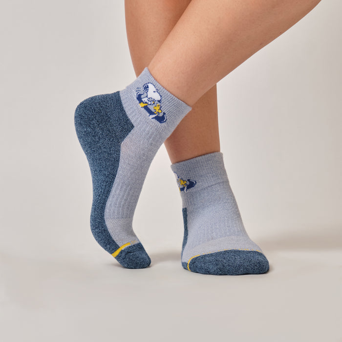 Light blue and denim marl quarter compression socks with a Snoopy canoe design, worn in an outdoor setting.
