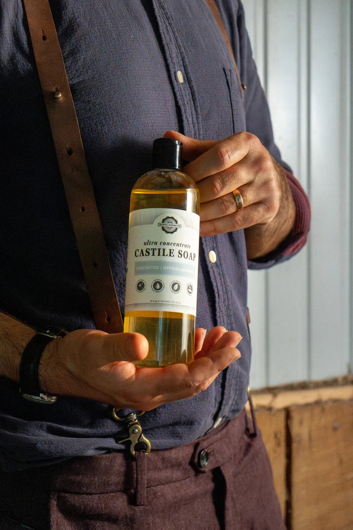 Rustic Strength - Person holding a 16 oz plastic bottle of Castile Soap - Ultra Concentrate | Unscented