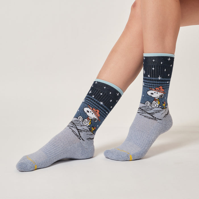 Light blue marl crew compression socks with a Snoopy starry night design, worn in an outdoor setting.