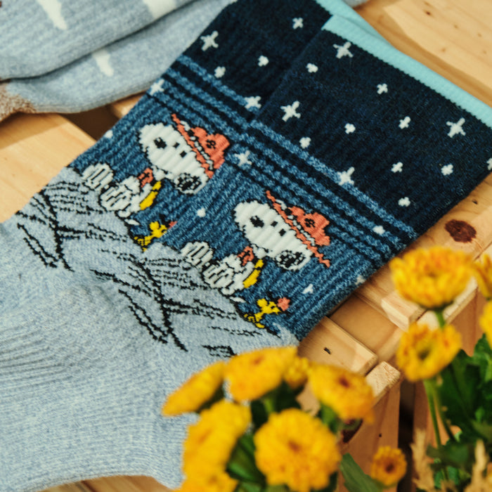 Light blue marl crew compression socks with a Snoopy starry night design, shown flat.